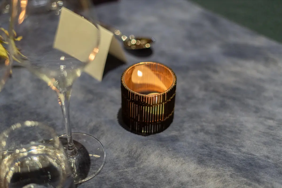 A candle, glasses and a place card on a table
