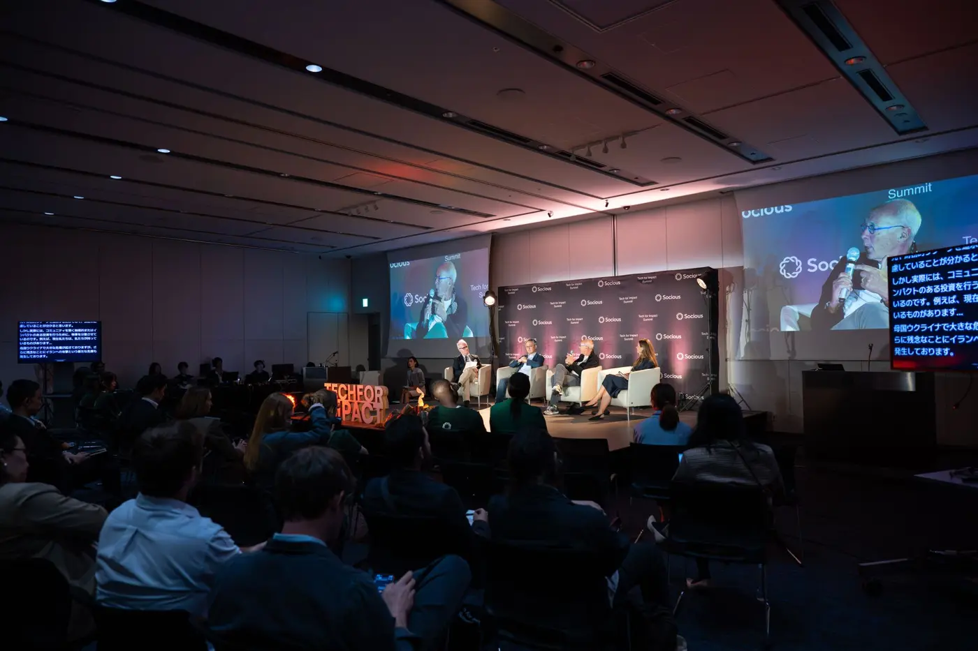 A panel on stage in front of a seated audience at the Tech for Impact Summit